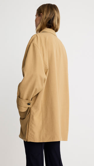 Person wearing a beige coat on a white background
