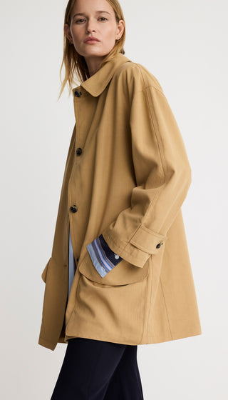 Woman wearing a beige coat on a white background