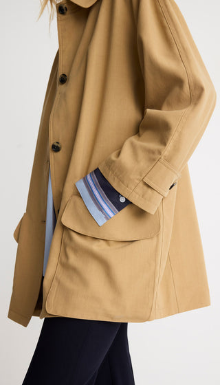 Tan coat with a pocket showing a striped shirt on a white background
