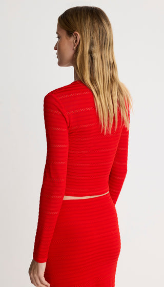 Woman wearing a red dress with long sleeves on a white background