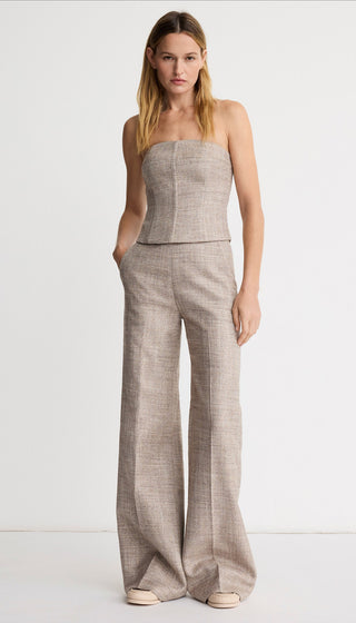 Woman wearing a strapless top and wide-leg pants on a white background