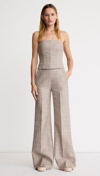 Woman wearing a strapless plaid jumpsuit on a white background