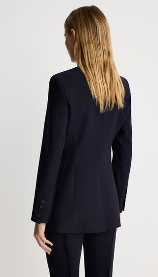 Person wearing a navy suit on a plain background