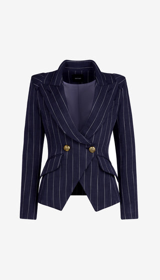 Person wearing a navy pinstripe blazer with gold buttons on a white background
